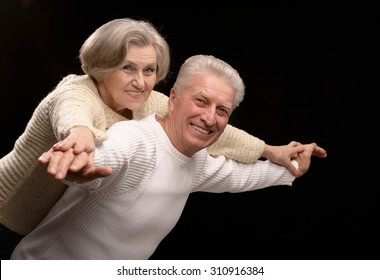 Ortrait Of Older Couple Embracing On A Black Background