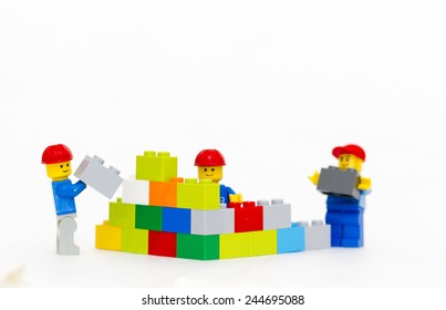 Orvieto, Italy - January 16th 2015: team of workman Lego mini figure build a wall. Lego is a popular line of construction toys manufactured by the Lego Group