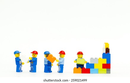 Orvieto, Italy - March 8th 2015: Group Of Workman Lego Mini Figure Build A Wall. Lego Is A Popular Line Of Construction Toys Manufactured By The Lego Group