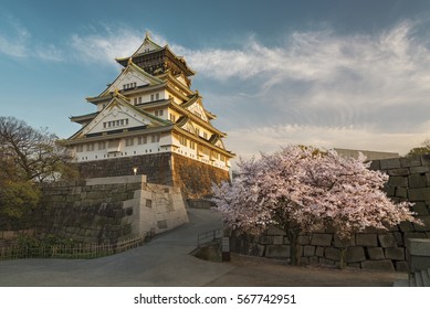 Osaka Castle With Sakura Blossom Under Sunset In Japan 