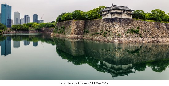 Osaka Castle Walls And Modern Office Buildings With Reflections In Moat 