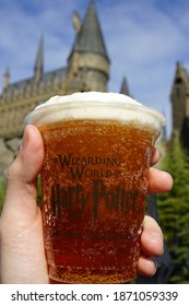 OSAKA, JAPAN- DECEMBER 10, 2020: Hand holding butterbeer cup at 'USJ or Universal studio Japan theme park' at The wizarding world of Harry Potter 