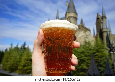 OSAKA, JAPAN- DECEMBER 10, 2020: Hand holding butterbeer cup at 'USJ or Universal studio Japan theme park' at The wizarding world of Harry Potter 