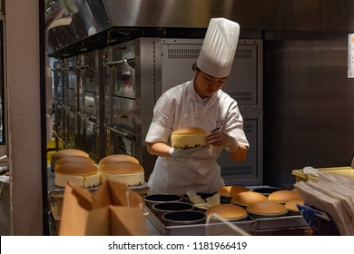 OSAKA, JAPAN - JAN 29, 2018: Pastry Chef Cooking The Famous Japanese Sponge Cake In Rikuro Ojisan Store Isolated