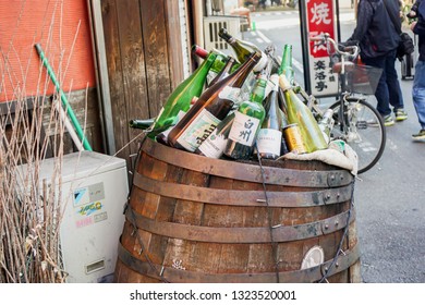 OSAKA, JAPAN, January 14, 2019 : Japanese Whisky Bottles And Liquor Bottle Is Left In The Old Wooden Trash Put On Bar Front In The Osaka City.