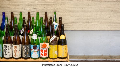 Osaka, Japan, January 17 2019 : Closeup and crop decorate and opened Japanese whisky bottles and liquor bottle on wooden shelves and wall of Japanese pub background. - Shutterstock ID 1379253266