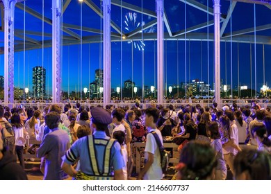 Osaka, Japan - July 25, 2015: Police officer overlooking crowd of people watching fireworks on bridge at Tenjin Matsuri summer festival