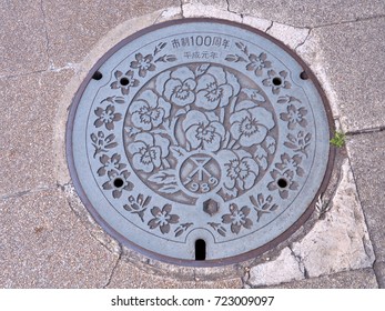 Osaka, Japan - June 9, 2016: A Manhole Cover Of Osaka City, Kansai Region, Japan. Many Flowers Engraved On Manhole Cover As A Memorial Of 100th Anniversary Of The City And First Year Of Heisei Period.