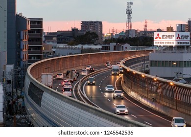 Osaka, Japan - November 10, 2018: Traffic On Hanshin Expressway Curves By Billboard For Mitsubishi Electric At Sunset