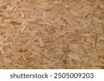 OSB board (Oriented Strand Board), showing overlapping wood fiber texture and light brown color