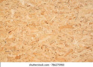 OSB boards are made of brown wood chips sanded into a wooden background. Top view of OSB wood veneer background, tight, seamless surfaces. - Shutterstock ID 786275983