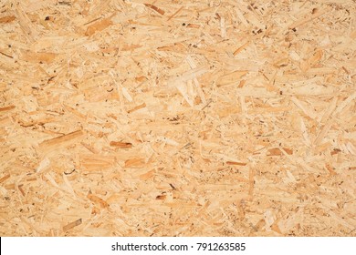 OSB boards are made of brown wood chips sanded into a wooden background. Top view of OSB wood veneer background, tight, seamless surfaces. - Shutterstock ID 791263585