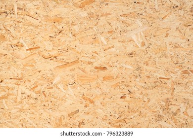 OSB boards are made of brown wood chips sanded into a wooden background. Top view of OSB wood veneer background, tight surfaces. - Shutterstock ID 796323889