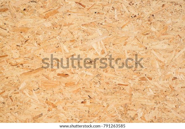 OSB boards are made of brown wood chips sanded
into a wooden background. Top view of OSB wood veneer background,
tight, seamless surfaces.
