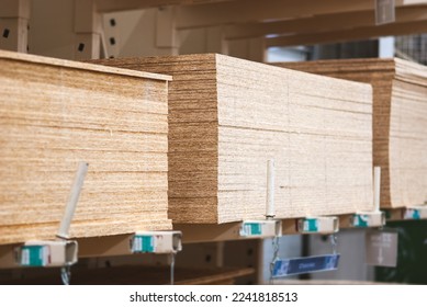 OSB boards in stock, chipboard stacked on pallets in building materials and supplies store - Shutterstock ID 2241818513