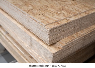OSB sheets are stacked in a hardware store. The building material is wood. - Shutterstock ID 1860707563