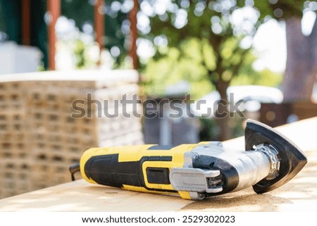 Oscillating Multi Tool Is Resting On A Piece Of Lumber During A Construction Project