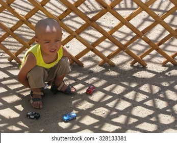 OSH, KYRGYZSTAN - 2 0JUL 2007: Little Children Play With His Toys Near A Newly Build Yurt Camp.