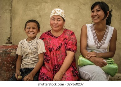 OSH, KYRGYZSTAN - JUN 3 2011: Family Seen At Their Mud Brick House Near Mountains Of Central Asia On Jun 3 In Kyrgyzstan.