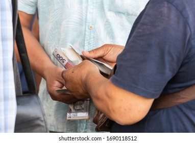 Osh, Kyrgyzstan - June 30, 2019: Man paying on the livestock market in Osh, Kyrgyzstan.