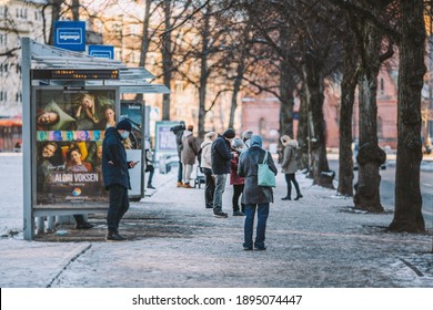 Oslo, Norway - 01.16.2021: People waiting for public bus transport at Sagene station wearing face masks during covid-19 pandemic