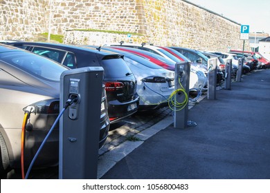 Oslo, Norway - 2016-10-05 : Electric cars plugged in and charging at a car park on the street in Oslo, Norway