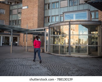 Oslo, Norway April 2017: Woman In Red Walk Outside The University Hospital Rikshospitalet