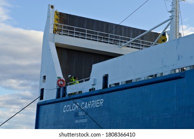 Oslo, Norway - Aug. 29th 2020: Two deckhands on a large cargo ship are securing the mooring lines while docking.