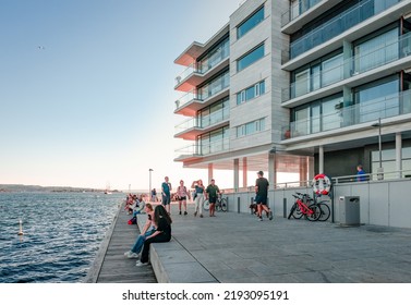 Oslo, Norway - August 13 2022: Incidental People Enjoy The Sunset On The Waterfront Of Tjuvholmen.