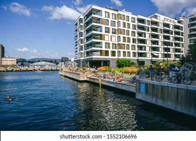 OSLO, NORWAY - JULY 28, 2019: People Are Swimming And Sunbathing On A Hot Sunny Summer Day In City Center, Tjuvholmen Neighborhood