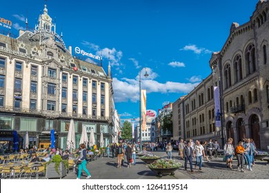 Oslo, Norway - June 5th 2018 - Big Group Of People Walking In Oslo City Center With Restaurant And Old Buildings In Norway