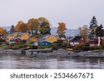 Oslo, Norway - October 20, 2024: Oslofjord (Oslofjorden), view of summer houses and cottages. Frame houses for recreation. Hut among the forest and rocks. Multicolored private houses.