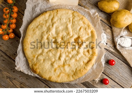 Ossetian pie with cheese and potatoes on wooden table top view Stock photo © 