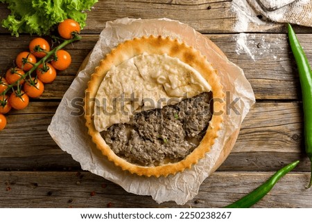 Ossetian pie with meat on old wooden table top view Stock photo © 