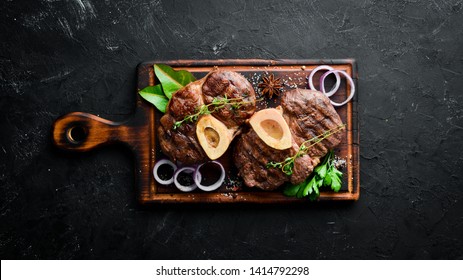Osso buco cooked Veal shank on a black background. Top view. Free space for your text.