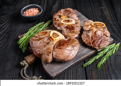 Osso buco cooked Veal shank steak, italian ossobuco. Black wooden background. Top view.