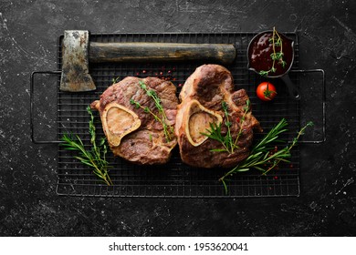 Osso buco cooked Veal shank with spices and rosemary. Barbecue meat. Top view. Flat lay top view on black stone cutting table.