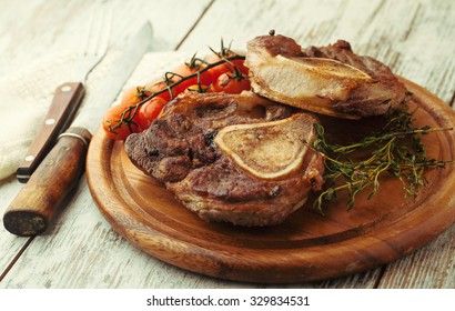 Osso buco roasted with thyme on a wooden background