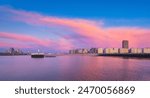 Ostend, Belgium. Panoramic view of the bay during sunset. Pier and lighthouse in the bay. Real estate on the coast. Bright sky and clouds. General view of the city.