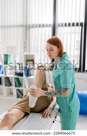 osteopath massaging injured leg of man during rehabilitation treatment in hospital