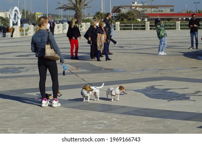 Ostia, Rome, Italy - 02 May 2021, Two Dogs On A Leash With The Mistress At The Ostia Roundabout.