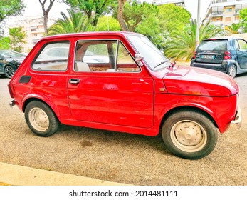 Ostia, Rome, Italy - July 14, 2021, a restored 1980s Fiat 126 model car in front of a mechanic's workshop.