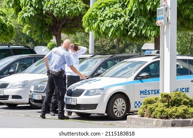 OSTRAVA, CZECH REPUBLIC-JUNE 15, 2020: Two Police Officers Arresting Young Man And Checking His Documents At Police Car In  Parking Lot Near Shopping Centre  Futurum In Ostrava. .