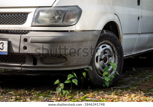 OSTRAVA, CZECHIA - OCTOBER 15,\
2020: The frontal part of old Fort Transit van parked for years at\
parking lot with grass growing around. Wreck on a public\
road.