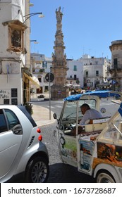 Ostuni, Italy. The Middle Of September 2017. The Central City Sguare With Sant Oronzo Monument And Mini Bus Driver On The Foreground.