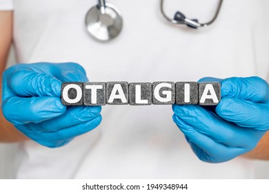 Otalgia - Word From Stone Blocks With Letters Holding By A Doctor's Hands In Medical Protective Gloves. Earache