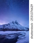 Otertind mountain, Lyngen Alps, Norway. Natural andscape. Starry sky and moon light. Long exposure photography in the mountain region. Winter night landscape with starry sky. 