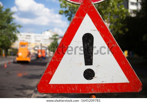 Other Dangers sign. Dangerous area. Traffic\
sign. Road works in the\
background.