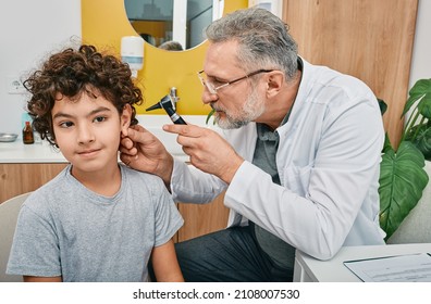 Otoscopy and hearing check-up for boy at audiology office. Audiologist examining child's ear with otoscope - Powered by Shutterstock