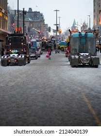 OTTAWA, CANADA - Feb 06, 2022: A Protestor With Canadian Flag Walking In Downtown Among The Truckers Protesting To The Federal Government The Vaccine And Mask Mandates In Canada 